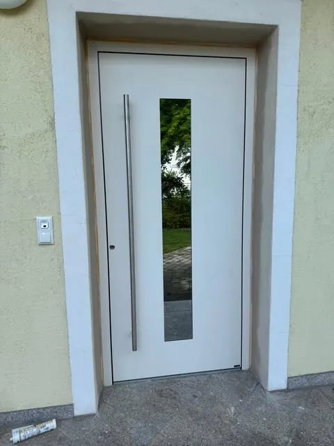 Weiße Haustür mit schmalem Glasstreifen und Edelstahlgriff