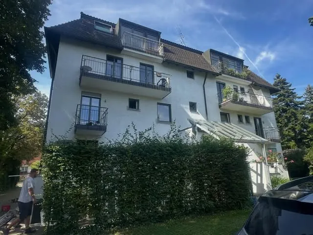 Weißes Mehrfamilienhaus mit Balkonen