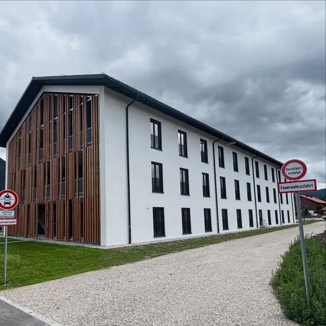 Mehrfamilienhaus mit Holzfassade und neuen Fenstern