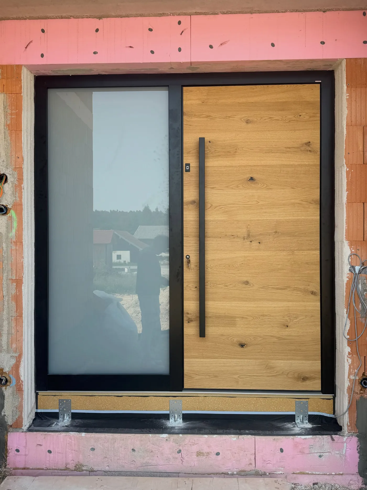 Neu eingebaute Schiebetür mit Holzfüllung und Glas